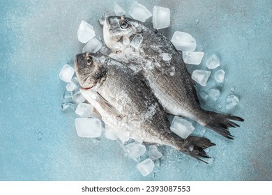 Raw fresh dorado or sea bream on ice cubes on blue concrete background. Long banner format. top view, - Powered by Shutterstock