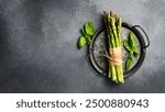 Raw fresh green asparagus on a plate. Cooking asparagus dishes. Top view.