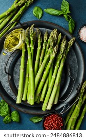 Raw fresh green asparagus on a plate. Cooking asparagus dishes. Top view.