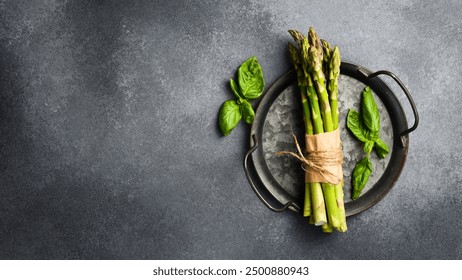 Raw fresh green asparagus on a plate. Cooking asparagus dishes. Top view.