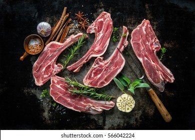 Raw fresh lamb chops meat and fork on dark background