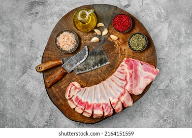Raw fresh lamb flap ribs with ingredients on wooden log, top view
