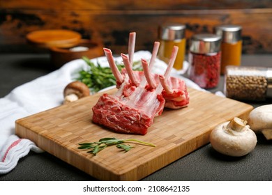 Raw fresh lamb ribs on wooden cutting board on dark background
 - Powered by Shutterstock