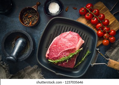 Raw Fresh Marbled Meat Beef On A Grill Pan Ready For Cooking On A Blue Concrete Background Top View