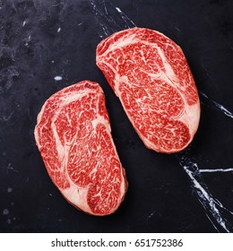 Raw fresh marbled meat Steak Ribeye Black Angus on black marble background