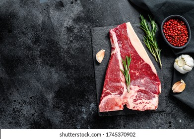 Raw fresh meat t-bone steak with spices, garlic and rosemary. Organic t bone beef. Black background. Top view. Copy space - Shutterstock ID 1745370902