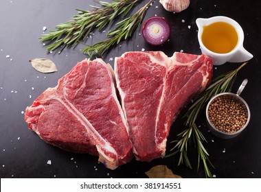 Raw fresh meat t-bone steak with spices, garlic and rosemary on a dark background - Powered by Shutterstock