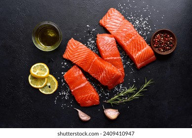 Raw fresh organic trout fillet with ingredients for cookin on a black slate, stone or concrete backgroundg. Top view with copy space. - Powered by Shutterstock