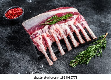 Raw fresh rack of lamb meat on marble board. Black background. Top view - Powered by Shutterstock