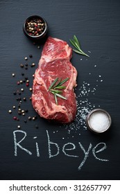Raw fresh ribeye beefsteak with sea salt, pepper and rosemary, studio shot - Shutterstock ID 312657797