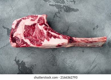 Raw fresh tomahawk black angus prime beef chop steak set, on gray stone background, top view flat lay, with copy space for text - Shutterstock ID 2166362793