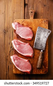 Raw Fresh Uncooked Pork Meat Steak On Bone On Cutting Chopping Board Block On Wooden Background