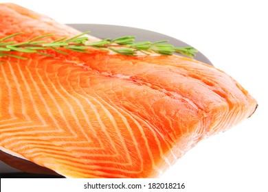 raw fresh uncooked salmon red fish fillet on black plate with rosemary twig isolated over white background - Shutterstock ID 182018216