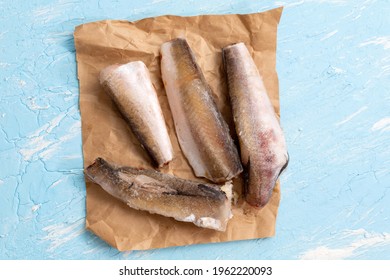 Raw Frozen Hake Fish On A Blue Background. Top View Copy Space