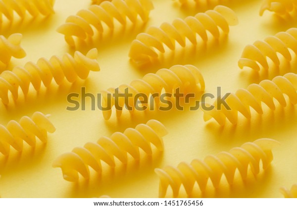 Download Raw Fusilli Pasta Over Yellow Background Royalty Free Stock Image PSD Mockup Templates