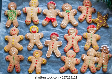 Raw gingerbread men with glaze on a baking sheet