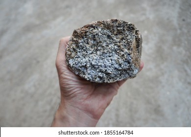 Raw Granite Rock Specimen In A Hand. Granite Is Coarse- Or Medium-grained Intrusive Igneous Rock