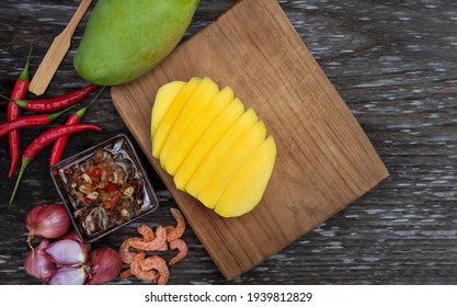 Raw Green Mango Slice With Sweet Fish Sauce On The Wooden Plate With Copy Space. Special Ingredient, Red Chili, Onion, Shrimp, Fish Sauce, Sugar And Shrimp Paste. Thailand Fruit Season.  Asia Style