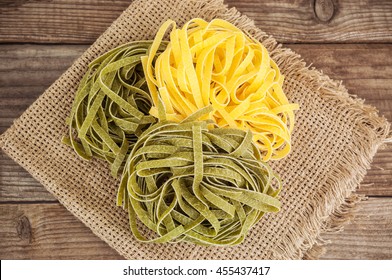 raw green and yellow egg fettuccine (italian pasta) on burlap napkin - Powered by Shutterstock