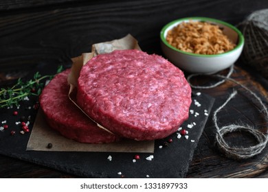 Raw Ground Beef Burger Cutlets With Seasoning And Fried Onions On Dark Wooden Board, Rustic Style