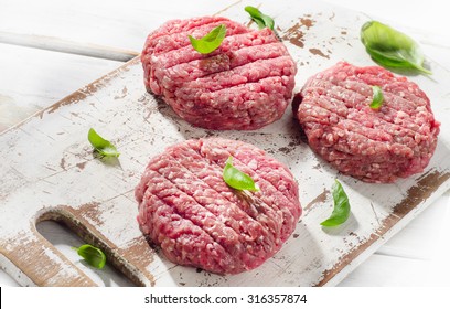 Raw Ground Beef Burger Steak Patties On A Wooden Cutting Board. Top View
