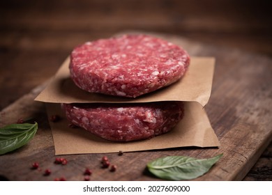 Raw ground beef meat burger steak cutlets on wooden background close up