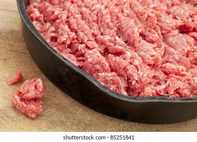 Raw Ground Bison (buffalo)  Meat On An Iron Pan Against Wood Surface