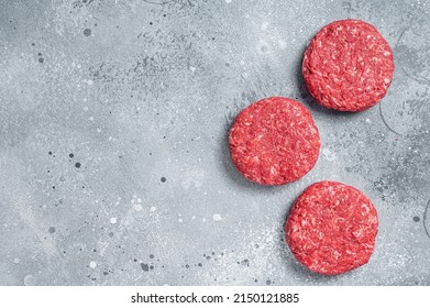 Raw Ground Mince Beef Meat Burger Steak Cutlets. Gray Background. Top View. Copy Space.