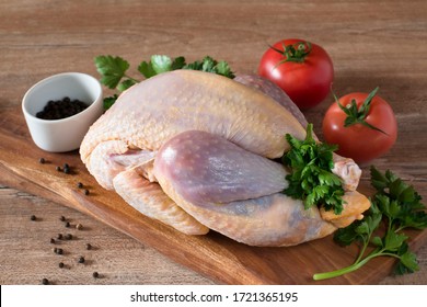 raw guinea fowl on a wooden board