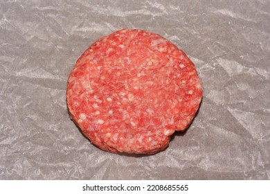 Raw Hamburger Patty Isolated On White Parchment Paper