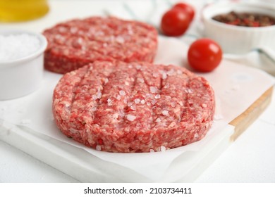 Raw Hamburger Patty With Salt On White Table, Closeup