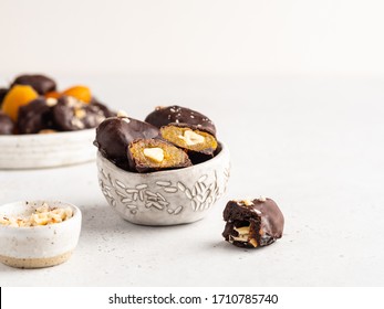 Raw and healthy candies, dried fruits and nuts in chocolate. Homemade vegetarian sweets.  Prunes, dried apricots, cashew nuts and almonds in dark chocolate. 