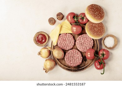 Raw homemade hamburger with fresh vegetables: lettuce, onions, tomato and ketchup. Top view, flat lay. Copy space - Powered by Shutterstock