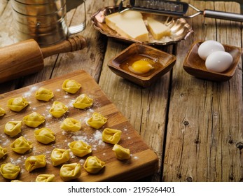 Raw Homemade Ravioli On A Cutting Board. Kitchen Utensils, Ingredients On A Wooden Kitchen Table. Recipes For Homemade Ravioli. Italian Food. There Are No People In The Photo.