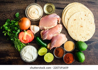 Raw Ingredients For Grilled Chicken Tacos And Pico De Gallo: Chicken Thighs, Flour Tortillas, And Other Taco Ingredients Viewed From Above