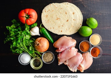 Raw Ingredients For Grilled Chicken Tacos With Toppings: Chicken Thighs, Flour Tortillas, And Other Taco Ingredients Viewed From Above