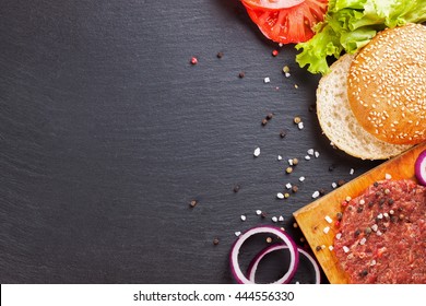 The raw ingredients for the homemade burger on black slate background. Top view. - Powered by Shutterstock