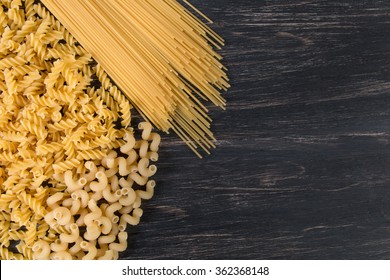 raw Italian pasta on a dark wooden background - Shutterstock ID 362368148
