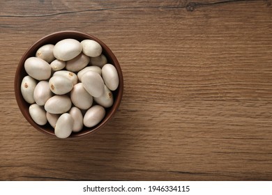 Raw jackfruit seeds on wooden table, top view. Space for text