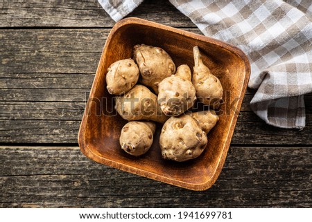 Raw jerusalem artichoke. Topinambur vegetable root in wooden bowl. Top view. [[stock_photo]] © 