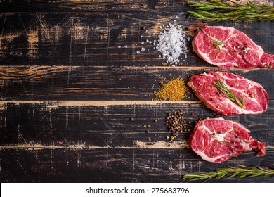 Raw Juicy Meat Steak On Dark Wooden Background