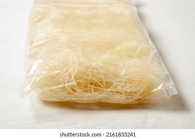 Raw Korean Starch Noodles Tanmen In Cellophane Packaging Close-up On A Gray Background.