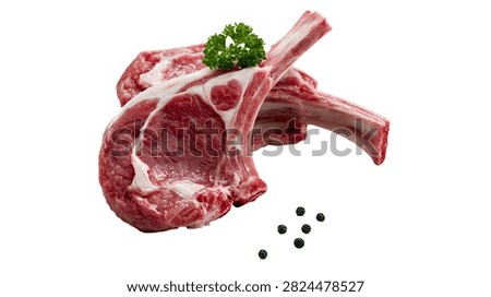 Raw lamb chops with bone and fresh green parsley garnish and black peppercorns