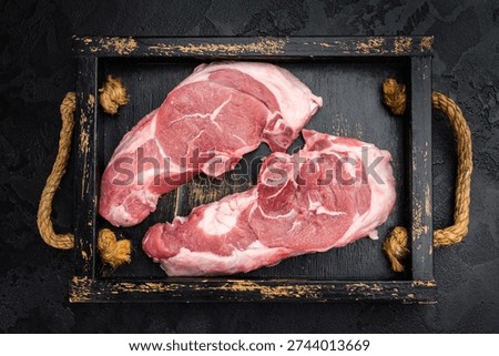 Raw lamb chump chops with bone served on rustic wooden tray with fresh thyme, premium sirloin saddle meat ready for grilling, roasting or gourmet cooking