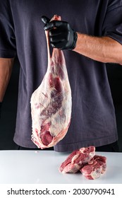 raw lamb ham in the hands of the chef. Male butcher holds in his hands raw meat lamb leg flesh. paleo diet, organic food.