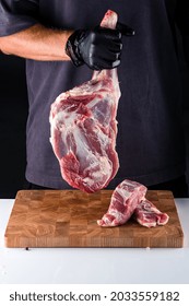 raw lamb ham in the hands of the chef. Male butcher holds in his hands raw meat lamb leg flesh. paleo diet, organic food.