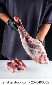 raw lamb ham in the hands of the chef. Male butcher holds in his hands raw meat lamb leg flesh. paleo diet, organic food.