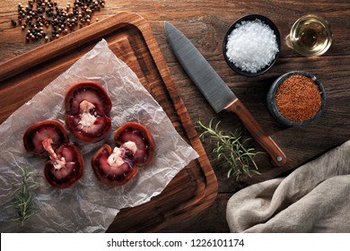 Raw Lamb Kidney On White Cooking Paper And Wooden Cutting Board. Decorated With Herbs, Spices, Chef's Knife And Napkin. Overhead View.