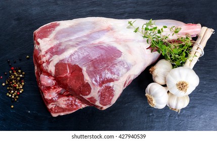 Raw lamb leg on blue stone background with herbs - Powered by Shutterstock