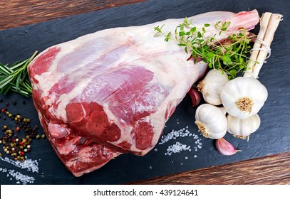 Raw lamb leg on blue stone background with herbs - Powered by Shutterstock